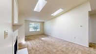 Located at 3200 Chestnut Ridge Drive in Pittsburgh, PA, this single-floor, one-bedroom, one-bathroom home offers a thoughtfully designed layout with comfortable living spaces throughout. The combined living and dining area is a standout, featuring two skylights that flood the room with natural light, a cozy fireplace with a classic white mantel, and neutral-toned carpeting that adds warmth underfoot. Two closet doors flank the fireplace wall, providing generous storage. The galley-style kitchen is well-appointed with white shaker cabinetry, light granite-look countertops, stainless steel appliances including a range, microwave, and refrigerator, a double-basin sink, and wood-look flooring that extends throughout the wet areas. The bedroom is a comfortable size, featuring its own ceiling fan, a window with outdoor views, and plush carpeting, with convenient access to the rest of the home. The full bathroom includes a tub-shower combination, wood-look flooring, and a vanity with ample counter space. A dedicated laundry area adds everyday convenience. The home's neutral color palette and textured ceilings contribute to a clean, move-in-ready ambiance throughout.
