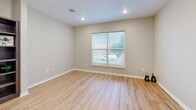 Located at 1020 Willowwood St in Denton, TX, this single-floor, one-bedroom, one-bathroom unit offers a practical and comfortable layout. The combined kitchen and living area forms the heart of the home, featuring light wood-style vinyl flooring, recessed lighting, and large windows that invite natural light and views of the surrounding neighborhood. The kitchen is equipped with rich, dark-toned wood cabinetry, white countertops, and a full suite of black appliances including a refrigerator, range, microwave, and dishwasher — offering a well-organized and functional cooking space. The open living area flows seamlessly from the kitchen, providing a bright and flexible space. The bedroom is carpeted for comfort, includes a ceiling fan with light fixture, a large sliding-door closet, and a window with blinds allowing for natural light. A second louvered closet is also visible, offering additional storage. The bathroom features matching dark wood cabinetry, a white countertop vanity with a single sink, light wood-style flooring, and a full tub-shower combination. A hallway connects the main living spaces, completing this efficient and cohesive floor plan.