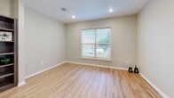 Located at 1020 Willowwood St in Denton, TX, this single-floor, one-bedroom, one-bathroom unit offers a practical and comfortable layout. The combined kitchen and living area forms the heart of the home, featuring light wood-style vinyl flooring, recessed lighting, and large windows that invite natural light and views of the surrounding neighborhood. The kitchen is equipped with rich, dark-toned wood cabinetry, white countertops, and a full suite of black appliances including a refrigerator, range, microwave, and dishwasher — offering a well-organized and functional cooking space. The open living area flows seamlessly from the kitchen, providing a bright and flexible space. The bedroom is carpeted for comfort, includes a ceiling fan with light fixture, a large sliding-door closet, and a window with blinds allowing for natural light. A second louvered closet is also visible, offering additional storage. The bathroom features matching dark wood cabinetry, a white countertop vanity with a single sink, light wood-style flooring, and a full tub-shower combination. A hallway connects the main living spaces, completing this efficient and cohesive floor plan.