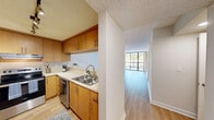 Located in Miami Lakes, Florida, this well-designed one-bedroom, one-bathroom residence offers a smart and efficient single-floor layout with a clean, neutral aesthetic throughout. Light wood flooring flows seamlessly across every room, complemented by crisp white walls and textured ceilings that lend a cohesive, airy feel to the entire space.

The open living area is bright and welcoming, benefiting from natural light and sliding glass door access, creating a comfortable and versatile space for everyday living. It connects naturally to the kitchen via a pass-through counter opening, which enhances the open feel. The kitchen is well-equipped with warm wood cabinetry, light countertops, stainless steel appliances including a range with overhead ventilation, and ample storage — a practical and attractive cooking space.

The bedroom is generously proportioned, featuring a window with outdoor views of lush greenery and providing a calm, private retreat. A hallway with closet access leads to the full bathroom, which includes a vanity with a mirror, white cabinetry, and a shower-tub combination — all finished with the same consistent light wood flooring.

Two hallways connect the rooms efficiently, and track lighting in the living area adds a functional design touch. The overall ambiance is clean, bright, and move-in ready, making this Miami Lakes residence a well-rounded and practical home.