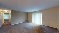 Located at 300 Four Seasons Dr in Mason, Ohio, this single-floor residence offers a functional and straightforward layout across several well-defined living spaces. The living room is generously sized, featuring wall-to-wall carpet and a large sliding glass door fitted with vertical blinds that allows abundant natural light to fill the room. Adjacent to the living area, the dining room is illuminated by a classic chandelier and connects directly to the kitchen through an open passageway, creating a cohesive flow between spaces. The galley-style kitchen is efficiently designed with warm wood cabinetry, light countertops, a stainless steel sink, and tile flooring. It also accommodates a full suite of appliances, including a refrigerator, stove, dishwasher, and in-unit washer and dryer. Two carpeted bedrooms each feature windows that invite natural light and outdoor views of the surrounding greenery, providing comfortable and quiet retreats. The full bathroom is clean and bright, finished with tile flooring, a vanity with storage, and a shower-tub combination. Throughout the residence, neutral tones and textured ceilings create a consistent and welcoming aesthetic.