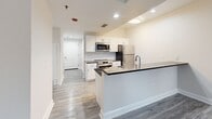 Located at 1601 Sansom St in the heart of Philadelphia's vibrant Rittenhouse Square neighborhood, this two-bedroom unit on the fifth floor offers a well-designed, efficiently laid-out living space. The open-concept kitchen is a standout feature, showcasing white shaker-style cabinetry, dark granite countertops, a subway tile backsplash, and a full suite of stainless steel appliances including a range, built-in microwave, refrigerator, and dishwasher. Light wood-style flooring runs throughout the kitchen and main living areas, lending a clean, contemporary feel. A peninsula counter provides additional prep space and a natural divider between the kitchen and the hallway leading to the entry. Both bedrooms are carpeted in a neutral tone, offering comfort underfoot. The primary bedroom is generously proportioned and features a window that allows natural light to fill the room. The second bedroom includes a mirrored sliding-door closet, maximizing both storage and the sense of space. Neutral wall tones throughout the unit create a calm, cohesive atmosphere that is easy to personalize. The overall design balances modern finishes with functional layout, making it a practical and comfortable residence in one of Philadelphia's most walkable urban neighborhoods.