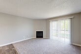Located at 10700 E Dartmouth Ave in Denver, CO, this one-bedroom, one-bathroom unit offers a practical and comfortable layout across a single floor. The living room serves as the centerpiece of the space, featuring soft carpeting, neutral gray walls, a textured ceiling, and a classic fireplace that adds warmth and character. Large sliding glass doors dressed with vertical blinds invite abundant natural light and provide access to an outdoor balcony with views of surrounding greenery. The transition from carpet to wood-style plank flooring marks the entry area, adding a touch of visual contrast and durability near the front door. The bedroom is a well-proportioned retreat finished with plush carpeting, neutral tones, and a window that allows natural light to filter in. A dedicated closet provides convenient storage. The bathroom is clean and functional, equipped with a full-size soaking tub and tiled shower surround with chrome fixtures. A kitchen with white cabinetry and a hallway connecting the main rooms complete the efficient floor plan. The unit's cohesive neutral palette and consistent finishes throughout create a calm, move-in-ready atmosphere well-suited for comfortable everyday living.
