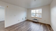 Located at 1323 SW Cherry Park Rd in Troutdale, Oregon, this well-designed 2-bedroom, 1-bathroom unit offers a practical and comfortable single-floor layout. Wood-look flooring flows consistently throughout, lending a cohesive and modern feel to every room.

The combined dining and living area is bright and open, featuring large windows with warm wood sills that invite natural light and offer views of the surrounding neighborhood. A wall-mounted climate control unit provides convenient temperature regulation.

The kitchen is efficiently designed with light maple cabinetry, white countertops, a stainless steel sink, and a full suite of stainless steel appliances including a refrigerator, electric range, and dishwasher. Recessed lighting and an under-cabinet range hood complete the functional space. Adjacent built-in cabinetry provides additional storage.

The primary bedroom is a comfortable size, featuring dual closets with arched panel doors and access to additional spaces. The second bedroom also benefits from natural light through large windows. Three closets throughout the unit offer ample storage.

The bathroom is clean and straightforward, equipped with a glass-door shower and wood-look flooring. Crisp white walls and trim throughout the unit contribute to a bright, neutral aesthetic well-suited for a variety of lifestyles.