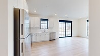 This thoughtfully designed two-bedroom, two-bathroom unit in Ankeny, Iowa offers a clean, modern aesthetic throughout its well-planned single-floor layout. Light wood luxury vinyl flooring flows seamlessly through every room, complemented by crisp white walls and striking black-framed hardware and door accents that provide a contemporary contrast.

The open-concept kitchen and living area serves as the heart of the unit. The kitchen is fully equipped with stainless steel appliances—including a refrigerator, range, built-in microwave, and dishwasher—paired with white shaker cabinetry, a subway tile backsplash, and light countertops. A large black-framed sliding glass door floods the living area with natural light and provides direct access to a private patio.

Both bedrooms are generously proportioned, each featuring oversized black-framed grid windows that bring in abundant natural light and outdoor views. Ceiling fans add comfort, and ample closet storage is provided throughout. The primary bedroom offers a comfortable footprint suited for a full furniture arrangement.

The two bathrooms maintain the unit's modern palette, with white vanities, light countertops, backlit mirrors, and black fixture accents. An in-unit laundry area adds everyday convenience. The overall ambiance is bright, clean, and move-in ready.