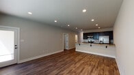 This well-appointed three-bedroom, two-and-a-half-bathroom townhome spans two floors, offering a generous and functional layout throughout. The main level features an open-concept living area with rich hardwood-style flooring, recessed lighting, and neutral-toned walls that create a bright, welcoming atmosphere. The kitchen is a standout feature, boasting dark espresso cabinetry, granite countertops, a full suite of stainless steel appliances including a range, microwave, refrigerator, and dishwasher, and a peninsula with bar seating that connects seamlessly to the living space. A half bathroom on the main floor adds everyday convenience, and a dedicated laundry area comes equipped with a full-size washer and dryer. The attached garage provides secure parking and additional storage space. Upstairs, three well-sized bedrooms feature the same hardwood-style flooring and ample natural light. Two full bathrooms serve the upper level, each finished with dark vanity cabinetry, granite countertops, stylish lighting fixtures, and tub-shower combinations. A carpeted staircase connects the two floors, adding a touch of warmth to the home's modern aesthetic. The cohesive design and quality finishes throughout make this townhome a comfortable and polished living space.
