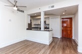 Located at 200 Colonial Homes Dr NW in Atlanta's 30309 zip code, this single-floor residence offers a thoughtfully designed open-concept layout with a clean, modern aesthetic throughout. The kitchen serves as a central focal point, featuring white shaker cabinetry with brushed nickel hardware, dark granite countertops, a classic white subway tile backsplash, and a full suite of stainless steel appliances including a refrigerator, electric range, and built-in microwave. A peninsula with a double stainless steel sink provides additional prep space and connects seamlessly to the living area. Light hardwood-style flooring flows throughout the main living spaces, complementing the bright white walls and recessed lighting. The open living area is generously proportioned, bathed in natural light from large windows, and features direct access to a private balcony with exterior views. The bedroom is carpeted for comfort, fitted with a ceiling fan, and also opens to the balcony. The bathroom is well-finished with a white vanity, dark granite countertop, and a tub-shower combination. A dedicated in-unit laundry area with a stacked washer and dryer adds everyday convenience to this polished Atlanta residence.
