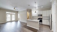 Located at 306 Ardmore Cir NW in Atlanta, GA, this well-appointed 2-bedroom, 2-bathroom residence offers a thoughtfully designed single-level layout. The open-concept living area features hardwood-style flooring, crown molding, a ceiling fan, and French doors that invite natural light while providing access to an outdoor space. The kitchen is a standout, outfitted with white shaker cabinetry, a subway tile backsplash, granite countertops, stainless steel appliances, a center island with an undermount sink, and stylish pendant lighting. A built-in desk nook adds a practical touch. Both bedrooms are carpeted and comfortable, with the primary suite including its own dedicated closet. The primary bathroom offers a double-sink vanity with granite countertops, white cabinetry, and hardwood-style flooring. The second bathroom mirrors the same refined finishes with a tub-shower combination. Two closets provide generous storage, including a spacious walk-in with wire shelving. The in-unit laundry room accommodates a full-size washer and dryer. Neutral tones throughout create a clean, cohesive ambiance well-suited to a variety of interior styles.