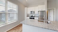 Located at 2331 Cadotte Dr SW in Wyoming, Michigan, this single-floor, 2-bedroom, 1-bathroom home offers a clean, modern aesthetic with thoughtful design throughout. The open-concept living area connects the living room, dining room, and kitchen, all finished with light wood-look flooring that adds warmth and continuity. The kitchen is a standout feature, boasting white shaker-style cabinetry, granite countertops, a central island with a sink, and a full suite of stainless steel appliances including a refrigerator, range, and over-the-range microwave. Multiple windows fill the living and kitchen areas with natural light. The two bedrooms are carpeted for comfort, each with windows that bring in outdoor light. The primary bedroom offers a generous footprint with ample space for furnishings. The full bathroom features a tub-shower combination, white cabinetry with granite countertops, and brushed nickel fixtures. Additional highlights include a dedicated office, a laundry room with full-size washer and dryer, a closet, and an entry foyer. Neutral gray walls and white trim carry throughout, creating a cohesive and move-in-ready environment.