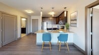 Located at 720 Van Rensselaer St in Syracuse, NY, this single-floor residence offers a thoughtfully designed layout with a blend of modern finishes and distinctive architectural details. The living area is a true standout, anchored by a dramatic arched window that frames sweeping waterfront views, flooding the space with natural light and creating an inviting, open ambiance.

The kitchen is well-equipped and features rich dark cabinetry, granite-style countertops, stainless steel appliances including a refrigerator, range, and microwave, and a peninsula with bar seating illuminated by pendant lighting — ideal for casual dining or entertaining. Wood-look flooring grounds the kitchen and common areas, providing a warm, cohesive aesthetic.

Each bedroom offers plush carpeting and generous closet space. The primary bedroom is highlighted by its own arched window with waterfront views, while an additional bedroom includes double doors to a spacious closet. The bathrooms are finished with light tile flooring, dark vanity cabinetry, granite countertops, and shower-tub combinations, reflecting a clean and contemporary style throughout.

The overall design of the residence combines comfort and modern elegance, making it a compelling home in the heart of Syracuse.