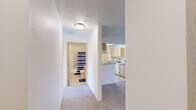 Located at 201 W Betz Rd in Cheney, Washington, this three-bedroom, two-bathroom single-floor residence offers a practical and well-organized layout. The living area features vaulted ceilings and plush carpeting, with a pendant light fixture adding a welcoming touch to the open space. The galley-style kitchen is equipped with light wood cabinetry, ample counter space, a full suite of white appliances including a range, refrigerator, and dishwasher, and tile flooring that flows throughout. A dedicated laundry area accommodates a full-size washer and dryer with overhead shelving for additional storage. Each of the three bedrooms is carpeted and filled with natural light through vertical-blind-covered windows, with baseboard heating providing warmth throughout. The primary bedroom offers a comfortable, well-proportioned space with closet access. Both bathrooms feature tub-shower combinations, wood-toned vanity cabinetry, and hard-surface flooring. A hallway connects the bedrooms and bathrooms, contributing to a well-defined and efficient floor plan. The overall aesthetic is clean and neutral, making this residence in Cheney, WA a straightforward and functional living space.