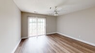 Located at 111 Northwynd Cir in Lynchburg, VA, this single-floor, three-bedroom, two-bathroom home offers a practical and comfortable layout. The combined kitchen and living area forms the heart of the home, with the kitchen featuring warm oak cabinetry, white countertops, wood-style flooring, and full appliances including a refrigerator and dishwasher. The living room extends naturally from the kitchen and is highlighted by sliding glass doors dressed with vertical blinds, allowing generous natural light and outdoor access. Ceiling fans are present throughout the bedrooms and living areas, promoting year-round comfort. The spacious primary bedroom includes its own walk-in closet, outfitted with wire shelving and carpeted flooring for added warmth. Additional bedrooms are carpeted, each featuring ceiling fans and windows that bring in natural light. Both bathrooms are finished with clean, neutral tones, wood-style or tile flooring, and tub-shower combinations with white surrounds and single-sink vanities. Neutral gray walls and white trim carry throughout the entire home, creating a cohesive and move-in ready aesthetic. The layout is efficient and well-organized, making excellent use of the available space.