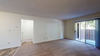 Located at Wayside Plaza in Pleasant Hill, California, this single-story unit offers a practical and comfortable layout across several well-defined spaces. The living area is generously proportioned, featuring wall-to-wall carpeting, neutral walls, and a textured ceiling. A sliding glass door opens directly to a private balcony, bringing in natural light and views of surrounding greenery, creating a seamless connection between indoor and outdoor living.

Adjacent to the living area, the kitchen is equipped with rich, warm-toned wood cabinetry, granite-style countertops, wood-look vinyl flooring, and white appliances including a range, microwave, refrigerator, and dishwasher. A pass-through opening connects the kitchen to the living and dining area, enhancing the open feel of the space.

The bedroom features soft carpeting, a sliding window with outdoor views, and access to a walk-in closet with built-in shelving, offering ample storage. The bathroom is finished with a white vanity cabinet, undermount sink, dark countertop, a mirrored medicine cabinet, and a shower-tub combination, all set on wood-look flooring. Throughout the unit, the design prioritizes functionality with a clean, understated aesthetic.