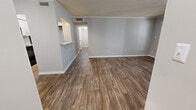 Located at 2439 Meadowridge Ln 27E in Montgomery, Alabama, this single-floor residence offers a well-designed layout that balances open living areas with comfortable private spaces. The main living area is finished with durable wood-look plank flooring and neutral gray walls, creating a clean and modern aesthetic. A standout fireplace with a classic black surround serves as a focal point, adding warmth and character to the space. Crown molding and a textured ceiling add subtle architectural detail throughout the common areas. The galley-style kitchen is efficiently organized with white cabinetry, gray laminate countertops, a double-basin sink, and stainless steel appliances including a refrigerator, range, and microwave. A pass-through counter connects the kitchen to the living area, while a chandelier illuminates the adjacent dining space. The bedrooms are carpeted for comfort and each features a ceiling fan with light. A generously sized walk-in closet with wire shelving provides ample storage in the primary bedroom. Both bathrooms are appointed with white tile tub-and-shower combinations, and one includes a vanity with a single sink and gray countertop. Wood-look flooring continues into the hallways, tying the layout together cohesively.