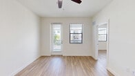 Located at 3681 Michigan Ave in Fort Myers, FL, this one-bedroom, one-bathroom unit offers a well-designed layout with a clean, modern aesthetic. Light wood-look flooring runs throughout the space, complementing the crisp white walls and creating a bright, cohesive feel.

The open-concept kitchen and living area serves as the heart of the unit. The kitchen is outfitted with white shaker-style cabinetry extending to the ceiling for generous storage, stainless steel appliances including a refrigerator, range, and built-in microwave, and a large white quartz island with an integrated sink — ideal for both meal prep and casual dining. Bright overhead lighting enhances the clean, contemporary look.

The living area is airy and open, featuring a ceiling fan and access to a private balcony through a glass door, allowing natural light to pour in alongside views of the surrounding neighborhood and lush palm trees.

The bedroom is a comfortable retreat with its own ceiling fan, a large window with natural light and outdoor views, and a dedicated closet for storage.

The bathroom maintains the unit's clean design language with white cabinetry, a white countertop vanity with an undermount sink, wood-look flooring, and a walk-in shower. Brushed nickel fixtures add a polished finishing touch throughout.