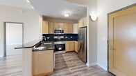 Located on the 8th floor at 66 Main St in Yonkers, NY, Unit 822 is a well-appointed one-bedroom, two-bathroom residence offering a thoughtfully designed single-level layout. The open-concept living and dining area is bright and spacious, featuring light hardwood-style flooring throughout and large sliding windows that frame views of the surrounding Yonkers cityscape, filling the space with natural light.

The kitchen is a standout feature, equipped with light maple cabinetry, dark granite countertops, a bold slate-tile backsplash, and a full suite of stainless steel appliances including a range, built-in microwave, dishwasher, and refrigerator. A peninsula with an integrated sink connects the kitchen seamlessly to the living area.

The generously sized primary bedroom offers wide windows with urban views, continuing the hardwood-style flooring found throughout the unit. Three closets provide ample storage across the residence. A dedicated laundry area adds everyday convenience.

The two bathrooms are clean and functional: one features a sliding-door shower stall with a white vanity, while the second includes a full soaking tub with tiled surround, a vanity with under-cabinet storage, and a well-lit mirror. Both bathrooms feature classic tile flooring in a neutral palette, complementing the unit's overall modern and understated aesthetic.