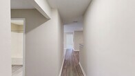 Located at 8242 Durelee Ln in Douglasville, GA, this single-floor residence offers two bedrooms and two full bathrooms across a well-utilized floor plan. The open living room is a standout space, featuring plush carpeting, a ceiling fan with light fixture, and large windows that invite generous natural light and outdoor views. The layout transitions seamlessly from the living area into the galley-style kitchen, which is outfitted with gray shaker-style cabinetry, granite-look countertops, a double stainless steel sink, and white appliances including a range and refrigerator. Wood-look tile flooring runs throughout the kitchen and hallway areas, providing a clean contrast to the carpeted living and bedroom spaces. Both bedrooms are well-proportioned, each equipped with a ceiling fan and window with blinds. The spacious primary bedroom offers ample room for furnishings. Each bathroom includes a tub/shower combination, vanity with storage, and tile flooring. A hallway connects the main living areas to the bedrooms and closets, maintaining a functional flow throughout the home. Textured ceilings and neutral warm-toned walls are consistent throughout, creating a cohesive and move-in-ready aesthetic.