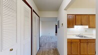 This 2-bedroom, 1-bathroom residence in Chesterfield, Michigan, offers a practical and well-organized single-floor layout designed for comfortable everyday living. The interior features neutral-toned carpeting throughout the main living and bedroom areas, creating a cohesive and easy-to-maintain aesthetic.

The kitchen is efficiently arranged in a galley style, featuring warm oak cabinetry, white laminate countertops, tile flooring, and white appliances including an electric range and dishwasher. An open passageway connects the kitchen directly to the living area, which receives natural light through a window overlooking the exterior.

The primary bedroom is generously sized with plush carpeting, a large window fitted with vertical blinds, and a walk-in closet that provides substantial storage space. Dark-toned sliding closet doors add a contrasting design element to the room. The second bedroom is equally spacious with soft carpeting and direct hallway access.

A central hallway connects all areas of the unit and features louvered bifold closet doors for additional storage. The full bathroom is clean and functional, appointed with tile flooring, a vanity with wood cabinetry, and a tiled shower-tub combination. The overall design is straightforward and practical, making this unit a solid option in the Chesterfield area.