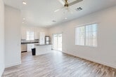 Located at 5821 W McDowell Rd in Phoenix, Arizona, this single-story home offers a clean, modern design with two bedrooms and three bathrooms across a well-utilized floor plan. The open-concept kitchen and living area serves as the heart of the home, featuring light wood-look flooring, recessed lighting, and a ceiling fan. The kitchen is equipped with stainless steel appliances including a range, microwave, dishwasher, and refrigerator, complemented by crisp white shaker cabinetry, a tile backsplash, dark countertops, and a central island with additional counter space. A sliding glass door connects the living area to the exterior, flooding the space with natural light. The primary bedroom is generously sized with vaulted ceilings, a closet, and direct access to a private bathroom featuring white cabinetry, dark countertops, and wood-look flooring. The second bedroom is bright and airy, with multiple windows, a ceiling fan, and ample natural light. Each bathroom maintains a consistent modern aesthetic with clean white finishes and brushed nickel fixtures. A dedicated closet adds practical storage. The exterior features desert-friendly landscaping with gravel, a small patch of grass, and a patio area.