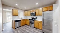 Located at 1200 Charleston Green in Malvern, PA, this two-story, 2-bedroom, 3-bathroom home offers a well-organized layout spread across two floors. The main level features a bright living room with durable wood-look plank flooring and a classic fireplace as a focal point, creating a warm and inviting atmosphere. A carpeted staircase with wood and metal railings connects the two floors, with views of the kitchen and an in-unit stacked washer/dryer from the landing. The kitchen is well-appointed with warm honey-toned cabinetry, white tile backsplash, light countertops, and a full suite of stainless steel appliances including a range, microwave, dishwasher, and refrigerator. Wood-look flooring extends throughout the main level, adding a cohesive, modern feel. A half bathroom on the main floor features wood-look tile, a white vanity, and clean, simple finishes. Upstairs, two generously sized bedrooms are finished with plush carpeting and feature windows that bring in natural light. The spacious primary bedroom offers ample room for comfortable living. Three bathrooms in total serve the home efficiently. Neutral tones throughout create a calm, move-in-ready environment suited for a variety of lifestyles.