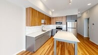 This 510 square foot apartment in Edina, Minnesota, offers a thoughtfully designed living space with two bedrooms and one bathroom. The property showcases a blend of modern aesthetics and practical functionality. The kitchen is a standout feature, boasting a sleek design with a mix of warm wood and cool gray cabinetry. It's equipped with stainless steel appliances, including a refrigerator, microwave, and dishwasher. The white subway tile backsplash and quartz countertops add a touch of elegance.

The primary bedroom, measuring 130 square feet, provides ample space and features neutral-toned carpeting and walls, creating a serene atmosphere. Both bedrooms benefit from natural light through large windows with roller shades. The bathroom continues the modern theme with a floating vanity, large mirror, and wood-look flooring.

Throughout the apartment, you'll find a cohesive design with neutral color palettes and a mix of carpeted and hardwood floors. The layout maximizes the use of space, with a hallway connecting the rooms efficiently. Built-in closets offer practical storage solutions. The overall ambiance is one of contemporary urban living, perfect for those seeking a compact yet stylish home in Edina.