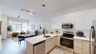 Located at 415 Stump Rd in Montgomeryville, PA, this thoughtfully designed one-bedroom, one-bathroom residence offers a modern aesthetic with clean lines and warm, neutral tones throughout. The open-concept kitchen and living area serves as the heart of the home, where a sleek kitchen showcases white upper cabinetry, light wood lower cabinets, stainless steel appliances, and a large peninsula with a waterfall-edge countertop — ideal for casual dining or entertaining. A linear pendant light anchors the space with contemporary style. The living room is bright and welcoming, featuring large windows that invite abundant natural light and outdoor views, complemented by light hardwood-style flooring that flows throughout. The bedroom is a calm retreat, highlighted by a textured accent wall, generous natural light from dual windows with outdoor views, and direct access to a dedicated closet. A versatile office space offers built-in shelving and a cozy layout suitable for remote work or a secondary lounge area. The bathroom features warm wood vanity cabinetry, hardwood-style flooring, and a clean, minimalist design with a combination tub and shower. Every room reflects a cohesive modern design with black hardware accents and a bright, airy ambiance.