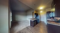 Located at 5840 Reed Lane SE in Salem, Oregon, this single-floor unit offers a thoughtfully designed layout that balances functionality and comfort. The open-concept living and kitchen area serves as the heart of the space, where wood-style hard flooring transitions seamlessly from the kitchen into the carpeted living area. The kitchen is outfitted with dark espresso cabinetry, granite-style countertops, stainless steel appliances including a refrigerator, dishwasher, microwave, and range, and a peninsula breakfast bar that provides additional seating and workspace. Neutral gray walls throughout create a clean, cohesive aesthetic.

The living area is generously proportioned and benefits from abundant natural light, with large windows and a sliding glass door opening to a private balcony with outdoor views. The bedrooms are carpeted and well-sized, each offering closet space with built-in rods. The bathroom features matching dark cabinetry with granite-style countertops and tile flooring. A dedicated laundry area with an in-unit washer and dryer adds a practical convenience, rounding out this well-equipped space.