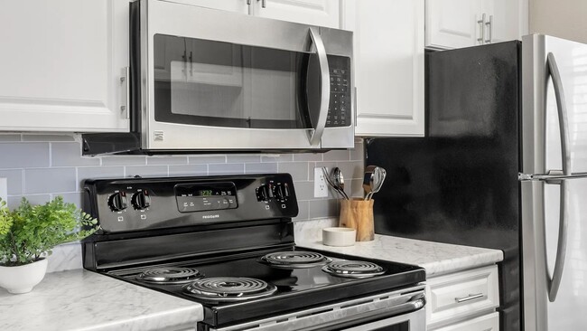 Luxurious stainless-steel appliances paired with stunning subway tile backsplash in every remodeled kitchen. - Promenade at Grand