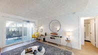 Located at 6363 Beadnell Way in San Diego, CA, this 2-bedroom, 1-bathroom single-floor unit offers a well-organized layout designed for comfortable everyday living. The bright living room features light wood-style flooring, a textured ceiling, and sliding glass doors that open to a private patio, allowing natural light to fill the space. The open flow connects the living area to the dining space and kitchen, creating a cohesive area ideal for both relaxing and entertaining. The kitchen is thoughtfully appointed with white shaker-style cabinetry, black hardware, light quartz countertops, a stainless steel sink, and black appliances including a range, microwave, dishwasher, and refrigerator. Light wood flooring continues throughout the kitchen and dining area. Both bedrooms are carpeted and offer a comfortable footprint, with the primary bedroom providing a generous amount of space. Each bedroom includes dedicated closet storage. One bedroom features a sliding glass door with direct patio access, adding an additional connection to the outdoors. The shared full bathroom includes a single-sink vanity with white cabinetry and a shower/tub combination. A hallway connects the main living areas to the bedrooms, providing a practical and efficient flow throughout the home.