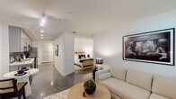 Located at 1120 W 6th St in the vibrant Westlake neighborhood of Downtown Los Angeles, this modern single-floor unit showcases a clean, contemporary design with polished concrete floors flowing throughout. The open layout connects the living area to the rest of the unit seamlessly, with crisp white walls creating a bright and airy atmosphere. A large window in the living room invites natural light and offers a glimpse of surrounding greenery, complementing the minimalist aesthetic.

The kitchen is well-appointed with floor-to-ceiling grey cabinetry, a striking dark subway tile backsplash, white quartz countertops, and a full suite of stainless steel appliances including a gas range, built-in microwave, refrigerator, and dishwasher — ideal for everyday cooking and entertaining. A dedicated hallway leads to a private bedroom featuring soft carpet flooring and a calm, restful ambiance. The bathroom is finished in a clean, all-white palette with a shower/tub combination and a modern vanity. Completing the unit is a space-efficient stacked in-unit washer and dryer, offering added convenience. The overall design balances urban functionality with understated style.