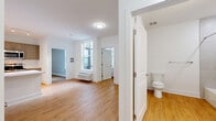 Located at 1001 W Elizabeth Ave in Linden, NJ, this 2-bedroom, 2-bathroom residence offers a thoughtfully designed single-floor layout with modern finishes throughout. Light wood-tone flooring flows seamlessly across all rooms, complemented by clean white walls and trim that create a bright, cohesive aesthetic.

The open-concept living, dining, and kitchen area forms the heart of the unit. The kitchen is equipped with stainless steel appliances — including a refrigerator, electric range, and over-the-range microwave — paired with taupe shaker-style cabinetry, white subway tile backsplash, and a white countertop island. Large windows invite natural light into the living and dining space, which also features a wall-mounted HVAC unit.

Both bedrooms are generously proportioned with neutral gray walls, large windows, and wood-tone flooring. The primary bedroom includes two closets, offering ample storage. The second bedroom is equally well-lit and comfortable.

The two bathrooms each feature wood-tone flooring and clean white finishes. One bathroom includes a glass-enclosed walk-in shower with tiled walls, while the second offers a full tub-shower combination. Additional highlights include four closets throughout, a dedicated laundry area, and a welcoming entrance — making this a highly functional and move-in ready residence.