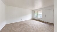 Located at 1601 NW 30th St in Oklahoma City, Oklahoma, this one-bedroom, one-bathroom unit offers a practical and efficient single-floor layout. The open living area is finished with neutral carpeting and features a large window that allows natural light to fill the space, providing views of the surrounding greenery. A baseboard heating system is integrated along the walls, ensuring year-round comfort. The kitchen is laid out in a galley style, featuring white cabinetry with brushed nickel hardware, light-toned countertops with ample workspace, a stainless steel sink, and white appliances. Wood-look vinyl flooring runs throughout the kitchen, offering both durability and visual warmth. The bedroom is a well-proportioned space with soft carpet flooring, a textured ceiling, a window for natural light, and baseboard heating. It is complemented by a dedicated walk-in closet lined with multiple shelving units and hanging rods, providing generous storage capacity. The bathroom features wood-look vinyl flooring, a mirrored medicine cabinet, a standard toilet, and a tub-shower combination with classic white subway tile surround. A hallway connects the rooms, contributing to a logical and easy-to-navigate floor plan throughout the unit.