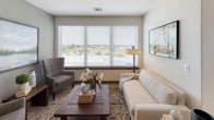 This single-story residence offers a thoughtfully designed layout that balances functionality with modern aesthetics. The kitchen serves as a central hub, featuring white shaker-style cabinetry, speckled quartz countertops, a subway tile backsplash, and a full suite of stainless steel appliances, including a French door refrigerator, range, microwave, and dishwasher. Light wood-look flooring flows throughout the kitchen and connects seamlessly to the living areas.

The living room is bright and welcoming, anchored by a wide window with outdoor views and fitted with blinds and neutral window treatments. The space accommodates comfortable seating arrangements and benefits from natural light throughout the day.

The bedrooms are carpeted and generously sized, each with large windows offering outdoor views. One bedroom features a bold blue accent wall and a ceiling fan, while others maintain neutral tones. A walk-in closet with white wire shelving and multiple hanging rods provides organized storage.

The bathrooms are finished with wood-look flooring, white vanity cabinetry, quartz countertops, and well-lit mirrors. The primary bathroom features a long double-vanity corridor connecting directly to the bedroom, enhancing the suite-like feel of the space.
