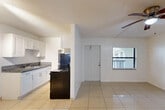 Located at 889 Riverside Dr in Fort Lauderdale, FL, this single-story, one-bedroom, one-bathroom home offers a practical and comfortable layout. Light-toned ceramic tile flooring runs throughout the entire space, lending a clean, cohesive look that is well-suited to the South Florida climate.

The combined dining and living area is bright and open, featuring a ceiling fan with light fixture and a window that invites natural light. The galley-style kitchen is efficiently designed with crisp white cabinetry, granite countertops, a stainless steel sink, and black appliances including a range and refrigerator — maximizing function within a compact footprint.

The bedroom is a generously sized retreat, complete with its own ceiling fan, a window with outdoor views of greenery, and direct access to three closets, providing excellent storage capacity. The bathroom is well-appointed with a full tub-shower combination, accented by classic tile surround in warm neutral tones.

Textured ceilings are consistent throughout the home. The clean white walls create a bright, airy ambiance across every room. With its straightforward layout and practical finishes, this Fort Lauderdale home offers a comfortable and low-maintenance living environment.