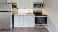 Located at 270 Laurel St in Hartford, Connecticut, this thoughtfully updated single-floor unit offers a bright and modern living experience. The open-concept layout seamlessly connects the living area to the kitchen, creating an inviting and functional space ideal for everyday living.

The kitchen is well-appointed with crisp white shaker-style cabinetry, light gray countertops, a classic white subway tile backsplash, and a full suite of stainless steel appliances, including a refrigerator, electric range, and over-the-range microwave. A single-basin sink with a brushed nickel faucet completes the clean, contemporary aesthetic.

The living area is generously proportioned, bathed in natural light from a large picture window that frames views of the surrounding Hartford neighborhood. Neutral gray walls and light-toned luxury vinyl plank flooring run throughout, lending a cohesive and modern feel to the space. Baseboard heating ensures year-round comfort.

The bathroom is finished with large-format gray floor tiles, a white shaker vanity, and a tub-shower combination fully tiled in white subway tile, giving it a fresh, spa-like quality. A frosted window provides natural light while maintaining privacy.

Overall, this space presents a clean, updated interior with consistent modern finishes in a well-established Hartford neighborhood.