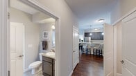 Located in Pickerington, Ohio, this well-designed two-bedroom, two-bathroom home offers a thoughtful single-floor layout that maximizes comfort and functionality. Rich, dark hardwood-style flooring flows through the main living areas, creating a warm and cohesive aesthetic throughout.

The open-concept kitchen is a standout feature, showcasing dark espresso cabinetry, light granite-style countertops, and a full suite of stainless steel appliances including a refrigerator, range, and built-in microwave. A central island with pendant lighting provides additional prep space and casual seating, seamlessly connecting the kitchen to the dining and living areas.

The living room is bright and inviting, with large windows that bring in natural light and a glass-paned door offering outdoor access. Neutral tones throughout create a calm, versatile backdrop.

The generously sized primary bedroom features plush carpeting, a wide window, and direct access to its own bathroom. The second bedroom is equally comfortable, also finished with carpet and natural light. Both bathrooms are neatly appointed with dark vanity cabinetry, single-sink counters, and clean tile flooring.

A dedicated walk-in closet with wire shelving provides ample storage. The overall design balances modern finishes with a welcoming, livable atmosphere.