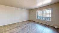 Located at 1201 N Alvernon Way in Tucson, AZ, this single-level, one-bedroom, two-bathroom unit offers a functional and efficiently designed layout. Light-toned luxury vinyl plank flooring runs throughout the home, lending a clean and cohesive look to every room.

The living room is a bright, open space anchored by a large window with vertical blinds that invite natural light and offer views of the outdoors. It flows directly into the galley-style kitchen, which is equipped with a white electric range, a full-size refrigerator, a stainless steel sink, and warm-toned wood cabinetry above and below the counter. A ceiling fan with a light fixture provides additional airflow and illumination in the kitchen area.

The bedroom is a well-proportioned, comfortable retreat featuring a window for natural light and direct access to a dedicated walk-in closet outfitted with built-in shelving — offering practical and organized storage. The two bathrooms include one full bath featuring a shower-tub combination with built-in wall shelving, and a second bathroom with a wide vanity, white cabinetry, a mirror, and a lighted fixture above. The neutral, cream-toned walls throughout the home create a calm, move-in-ready atmosphere well-suited to Tucson's desert setting.