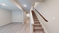 Located at 27035 Beacon Glen Drive in Katy, TX, this two-story home offers a well-designed layout spread across two floors. The main level features light hardwood-style flooring throughout, creating a cohesive and airy atmosphere. The open-concept kitchen is a standout, equipped with white shaker cabinetry, granite countertops, a subway tile backsplash, stainless steel appliances, and a peninsula with a built-in sink. An adjacent pantry provides additional storage. The living room is generously proportioned, featuring a ceiling fan, recessed lighting, and a trio of windows that invite abundant natural light. A carpeted staircase with a warm wood handrail connects the floors, complemented by a wide hallway on the main level. The upper floor houses all four bedrooms, each finished with plush carpet and natural light from windows with blinds. Each bedroom includes a dedicated closet, while the spacious primary bedroom benefits from a notably large footprint. The four bathrooms are clean and well-appointed, with one featuring a full tub-shower combo accented by white subway tile and a white vanity with ample cabinetry. The home's neutral color palette and consistent finishes throughout convey a modern, move-in-ready aesthetic.