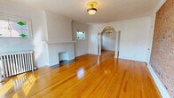Located at 12467 Cedar Rd in Cleveland Heights, Ohio, this well-appointed one-bedroom, one-bathroom unit showcases classic architectural character throughout its thoughtfully laid-out single floor. Gleaming hardwood floors flow seamlessly through each room, complementing the bright, neutral palette and crown molding that lend a timeless elegance to the space.

The spacious living room is a standout, featuring a white-tiled decorative fireplace, a charming stained glass window, and a vintage brass flush-mount ceiling fixture. A graceful arched opening flanked by decorative columns connects the living room to the dining room, which is illuminated by a classic chandelier. The dining room also boasts a striking exposed brick accent wall and large windows that invite abundant natural light.

The kitchen is efficiently designed with white cabinetry, a bold black marble-style backsplash, and black appliances including a gas range, dishwasher, and refrigerator, all set over warm hardwood flooring. The bedroom offers a comfortable footprint with a double-pane window, a radiator, and two closets — one fitted with a mirrored door.

The bathroom is clean and bright, featuring white tile flooring, a tub/shower combination, a vanity with dark countertop, a glass block window, and a decorative cast-iron radiator. A connecting hallway ties all spaces together cohesively.