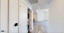 Located at 1950 Mayfair St in Naples, FL, this penthouse residence offers a thoughtfully designed, single-floor layout with four bedrooms, five bathrooms, and a generous overall footprint. The open-concept kitchen and living area serves as the heart of the home, showcasing floor-to-ceiling white cabinetry, a light blue tile backsplash, quartz countertops, and a large central island with a waterfall edge. Stainless steel appliances, including a refrigerator, range, microwave, and dishwasher, complete the contemporary kitchen. Light oak hardwood flooring flows consistently throughout, complementing the crisp white walls and creating a bright, airy ambiance. The bedrooms are well-proportioned, with the spacious primary suite offering generous dimensions and direct outdoor access via floor-to-ceiling sliding glass doors that open to a private balcony with open views. The five bathrooms are clean and modern, featuring white vanities with quartz counters, LED-backlit mirrors, and tub/shower combinations with white tile surrounds. Five closets—including walk-in closets with wire shelving systems—provide ample storage. A dedicated laundry room and utility space add to the home's functional practicality. Sliding barn doors and recessed lighting add refined architectural details throughout.