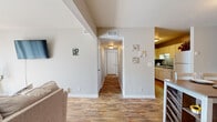 This single-floor, 2-bedroom, 2-bathroom residence offers a practical and comfortable layout with consistent wood-look flooring running throughout the home, lending warmth and visual continuity across every room.

The living room provides a welcoming, open atmosphere with neutral-toned walls, a wall-mounted television, and generous space for seating. It connects naturally to the dining area, which features two-tone wall treatment with wainscoting details and a window that allows natural light to brighten the space.

The kitchen is efficiently designed with white cabinetry, dark countertops, and white appliances including a range, dishwasher, and refrigerator. A notable feature is the in-unit washer and dryer, conveniently located within the kitchen area.

The primary bedroom is a spacious retreat with warm wood-look flooring and direct access to a dedicated closet. The second bedroom is bright and comfortable, benefiting from a window that draws in natural light. Both bathrooms are clean and functional, with one featuring a wide vanity with dark countertops, a large mirror, and ample cabinet storage below.

A central hallway connects the bedrooms and bathrooms, maintaining a logical and efficient flow throughout the home. The overall design is clean and understated, making it a versatile and move-in ready space.