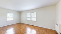 Located on North High Street in Columbus, Ohio, this two-bedroom, one-bathroom unit offers a well-organized single-floor layout with a cohesive, clean aesthetic throughout. Distinctive parquet hardwood flooring flows through the living room, hallways, and both bedrooms, lending a warm, classic character to the interior. The spacious living room is bathed in natural light from large windows and offers an open, versatile space ideal for everyday living. The primary bedroom is a comfortable size, featuring dual windows that invite ample natural light and greenery views, complemented by a ceiling fan. The second bedroom also features parquet flooring, a ceiling fan, and its own window with outdoor views. The kitchen is efficiently designed with white cabinetry, granite-style countertops, a stainless steel sink, and tile flooring, providing a practical and tidy cooking space. The bathroom is bright and clean, featuring a full tub-shower combination with chrome fixtures and a window for natural ventilation. Multiple hallways connect the rooms seamlessly, contributing to a logical and easy-to-navigate floor plan. The unit's neutral palette of whites and warm wood tones creates a welcoming, move-in-ready environment throughout.
