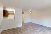 Located in Mountlake Terrace, WA, this one-bedroom, one-bathroom unit offers a thoughtfully designed single-floor layout. The open-concept living, dining, and kitchen area is bright and airy, featuring light-toned hardwood-style flooring, crisp white walls, and a textured ceiling with a ceiling fan overhead. A sliding glass door fills the living area with natural light and leads to a private balcony overlooking a tranquil, tree-lined green space — a serene outdoor retreat.

The kitchen is well-appointed with sleek taupe cabinetry, a striking marble-look quartz countertop, stainless steel appliances including a refrigerator and dishwasher, and a pass-through that connects to the main living area.

The bedroom features plush carpeting, a large closet with bi-fold doors, a window with garden views, and a baseboard heater. An additional closet provides extra storage within the unit. The bathroom is finished with modern touches, including a sliding glass walk-in shower, a wood-toned vanity with a quartz countertop, and coordinating hardwood-style flooring. Clean, neutral finishes throughout give the space a fresh, move-in-ready feel.