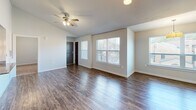 Located at 123 W 7th St in North Little Rock, AR, this well-appointed 2-bedroom, 2-bathroom single-story residence offers a thoughtfully designed floor plan across a comfortable footprint. The open-concept living room greets you with rich hardwood-style flooring, a ceiling fan, and an abundance of natural light streaming through multiple large windows that frame outdoor views. The layout flows seamlessly into the kitchen and dining area, where dark espresso cabinetry, granite countertops, stainless steel appliances, and stylish pendant lighting create a modern and functional cooking space. A peninsula countertop enhances the open feel while providing additional workspace. Both bedrooms feature plush carpeting, ceiling fans, and vaulted ceilings that lend a sense of openness, with windows providing natural light and outdoor views. The primary bedroom offers generous proportions and direct access to a dedicated closet and bathroom. Both bathrooms are finished consistently with dark wood cabinetry, granite-topped vanities, tile flooring, and full tub-shower combinations. Two closets provide practical storage throughout the home. The neutral color palette and cohesive design details give the space a clean, contemporary ambiance throughout.