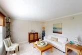 Located at 35 Clipper Ct in St. Augustine Beach, Florida, this 2-bedroom, 2-bathroom single-floor residence offers a well-organized layout with a relaxed coastal aesthetic. The open living room features crown molding, light neutral walls, and tile flooring that transitions seamlessly into the dining area, creating a welcoming and cohesive common space. Coastal-inspired decor and ample room for seating make this area ideal for both relaxing and entertaining.

The galley-style kitchen is efficiently designed with crisp white cabinetry, dark granite countertops, stainless steel appliances including a range, microwave, refrigerator, and dishwasher, and light tile flooring. A casual dining nook adjacent to the kitchen provides a functional everyday eating space.

The primary bedroom offers generous proportions, with wood-look flooring, a ceiling fan, and a window that brings in natural light. The second bedroom also features wood-look flooring and a clean, neutral palette. Both bathrooms are finished with tile flooring, warm wood vanities, and tub-shower combinations. Nautical accents in the bathrooms reinforce the home's coastal character.

Two hallways provide practical flow and connectivity between rooms, along with a dedicated closet for additional storage. This residence delivers a comfortable, move-in-ready coastal lifestyle in the heart of St. Augustine Beach.