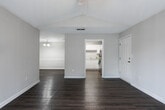 Located at 1116 Stone Mill Dr SE in Cartersville, Georgia, this single-story residence offers a well-organized layout with a variety of functional spaces. The living area features dark hardwood-style flooring and vaulted ceilings accented by a ceiling fan, with sliding glass doors that invite natural light and provide outdoor views, creating an open and airy atmosphere.

The kitchen is equipped with white raised-panel cabinetry, light countertops, and stainless steel appliances, including a range with overhead ventilation and a dishwasher. The space is efficiently designed to maximize storage and functionality.

The bedrooms are carpeted for comfort, with vaulted ceilings and ceiling fans adding to the spacious feel. The primary bedroom includes a walk-in closet with built-in shelving and direct access to a private bathroom. An additional bedroom also benefits from natural light through well-positioned windows.

Both bathrooms feature white cabinetry, single-basin vanities with white countertops, large mirrors, and hardwood-style flooring, maintaining a consistent, clean aesthetic throughout. Neutral wall tones and white trim are carried consistently across all rooms, contributing to a cohesive and tidy interior ambiance.