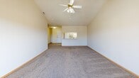 Located at 2901 Fletcher Ave in Lincoln, Nebraska, this one-bedroom, one-bathroom unit offers a thoughtfully organized single-floor layout with a comfortable and functional design throughout. The spacious living room is a standout feature, boasting vaulted ceilings, a ceiling fan with light fixture, plush wall-to-wall carpeting, and a corner fireplace that adds warmth and character to the space. A sliding glass door fills the room with natural light and provides direct access to an outdoor area with exterior views. The kitchen is designed in a classic galley style, featuring white cabinetry, light countertops, light wood-style flooring, a stainless steel sink, and white appliances including a refrigerator and range — offering efficient use of space and ample storage. The generously sized bedroom includes soft carpeting, a window for natural light, and access to a dedicated closet, providing practical storage. The bathroom is finished with wood-style flooring, a white vanity with countertop, a large mirror, and chrome fixtures for a clean, neutral aesthetic. Neutral tones and consistent finishes carry throughout the unit, creating a cohesive and inviting atmosphere ideal for comfortable everyday living.
