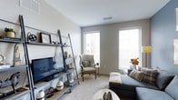 Located in the heart of downtown Columbus, Ohio, this single-floor residence at 150-190 S High St offers a modern and thoughtfully designed living environment. The living area serves as the centerpiece of the space, featuring neutral-toned walls and plush carpeting that create a warm, inviting atmosphere. Large windows allow generous amounts of natural light to pour in, offering views of the surrounding urban landscape and brightening the entire room. The living space is well-proportioned, comfortably accommodating a seating arrangement alongside decorative elements such as a lean-to media shelf that adds both style and functional storage. Ceilings are smooth and standard height, contributing to a clean, contemporary feel throughout. The overall design palette leans toward soft grays and whites, lending the space a calm and sophisticated ambiance. The layout is efficient and practical, making excellent use of the available floor plan. Positioned in one of Columbus's most vibrant neighborhoods, this residence provides convenient access to the city's dining, entertainment, and business districts, making it a compelling option for those seeking modern urban living in a prime downtown location.