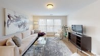 This thoughtfully designed 1-bedroom, 1-bathroom residence offers a cohesive and functional single-level layout with warm hardwood-style flooring flowing throughout. The kitchen is outfitted with white shaker cabinetry, quartz-style countertops, a subway tile backsplash, stainless steel appliances including a refrigerator, range, and built-in microwave, and a double sink positioned beneath a window. Adjacent to the kitchen, the dining area features direct access to the main entry and is accented by a round mirror and natural light. The living room is generously proportioned, with large windows that invite abundant natural light and offer outdoor views, complemented by a neutral color palette ideal for a variety of furnishing styles. The bedroom provides a comfortable retreat with a walk-in closet, soft neutral walls, and room for a full furniture arrangement. The full bathroom is clean and modern, featuring a combined shower and soaking tub with glass sliding doors, a white vanity with under-sink storage, and hardwood-style flooring. Throughout the space, the light-toned walls and consistent flooring create a bright, airy ambiance that feels both welcoming and easy to personalize.