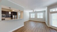 This single-story, two-bedroom, two-bathroom residence offers a thoughtfully designed layout with a blend of modern finishes and functional living spaces throughout. The open-concept living and dining area is anchored by warm wood-style hard-surface flooring, crown molding, and a ceiling fan, while multiple windows fitted with blinds allow ample natural light to fill the space. French doors with a transom window further brighten the living area and provide access to the outdoors.

The kitchen is positioned adjacent to the living area and features a pass-through granite-style countertop breakfast bar, dark espresso cabinetry, a white subway tile backsplash, and a full suite of stainless steel appliances including a refrigerator, range, and over-the-range microwave. Pendant lighting above the bar adds a refined touch.

Both bedrooms offer neutral tones and are carpeted for comfort. One bedroom includes hardwood-style flooring and a ceiling fan, along with a window for natural light. Each bedroom provides access to a closet for storage.

The two bathrooms are consistent in finish, each showcasing granite-style countertops, dark vanity cabinetry, undermount sinks, large mirrors, and wood-style flooring, presenting a clean and cohesive aesthetic throughout the home.